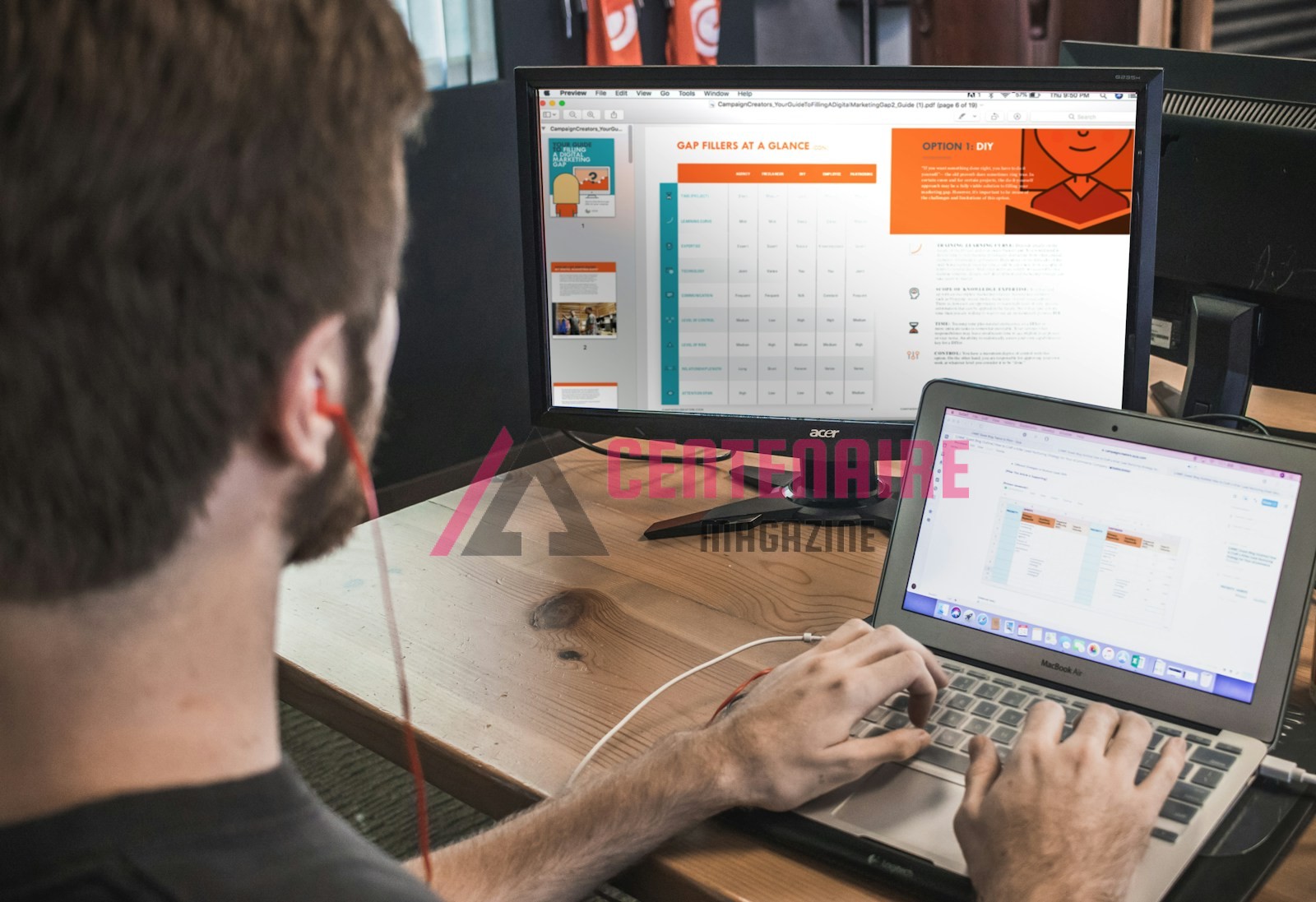 man wearing red earphone sitting on chair while using laptop